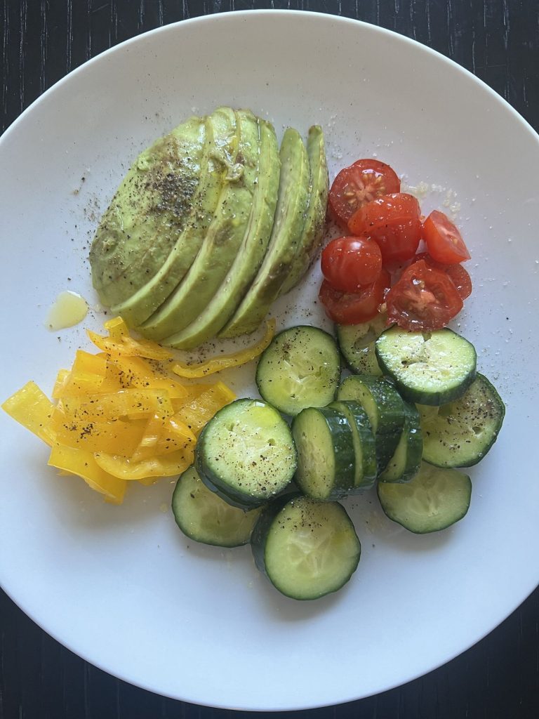 Fresh vegetables and olive oil arranged in a colourful seasonal bowl