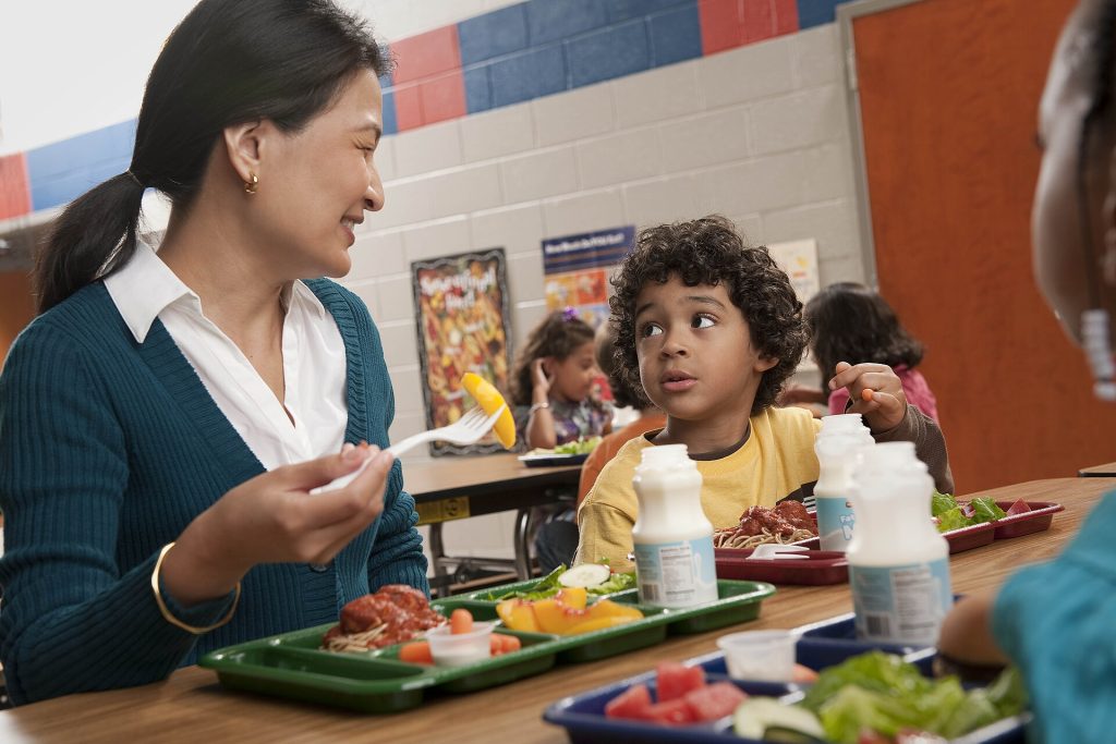 An Extra Serve of Fruit a Day: What a Major Teen Health Study Found School cafeteria lunch trays with fresh fruit being served to students